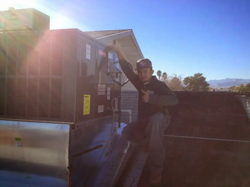 HVAC technician performing HVAC Inspection on a rooftop unit in Hutchinson